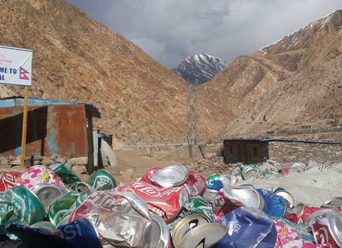 First steps in Nepal from Hilsa, April 2017
Borders are zones of contrasts. Piles of cans build up in front of the police post on the Nepal side of the border, just beyond the Chinese fence in Hilsa. These commodities are exclusively Chinese made, but no trace of garbage can be seen on the Chinese side of the frontier just a few meters away. The rows of decrepit metal shacks behind the sign post is the Nepal border police post as it stands today, staffed for not more than seven months of the year, which stands in sharp contrast to the fully staffed, large, and impressive Chinese customs and immigration building on the other side of the border open all year round.